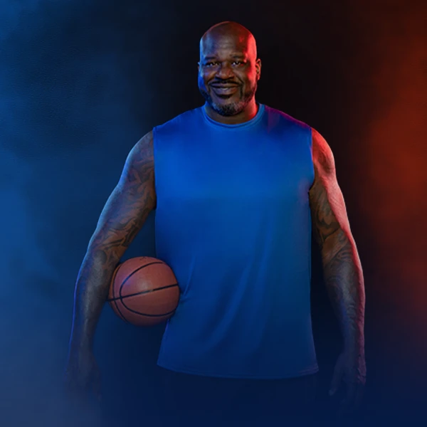Shaquille O'Neal standing with a basket ball under his right arm, and staring at the camera with a warm smile.